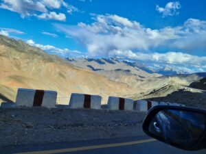Scenic road trip from Bangalore to Ladakh showing winding Himalayan roads, mountains, and adventure travelers on the journey